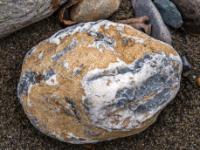 Weißer Quarzstein mit grauem Kern und ockerfarbenen Flächen